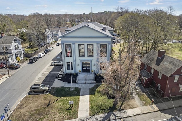 greek revival inspired property featuring uncovered parking