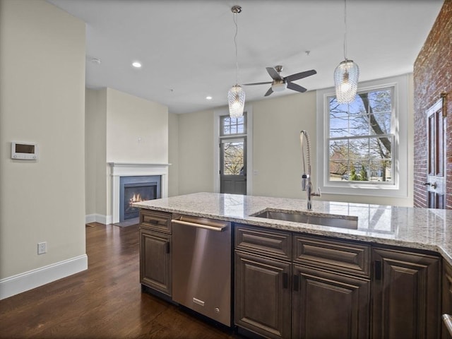 kitchen with a fireplace with flush hearth, a sink, baseboards, ceiling fan, and dishwasher