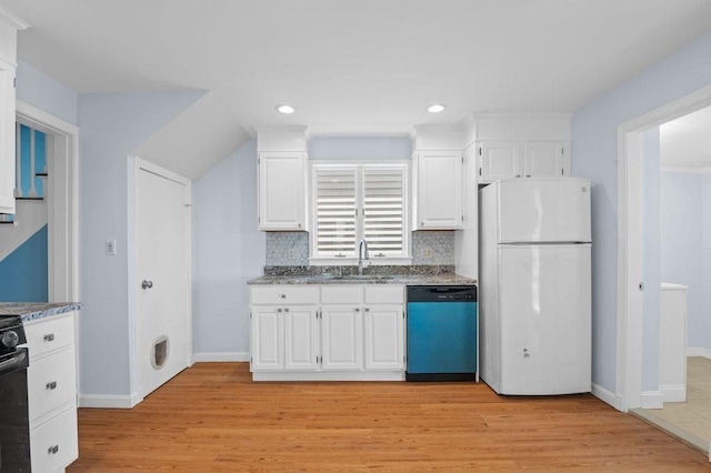 kitchen featuring freestanding refrigerator, light stone counters, a sink, and dishwashing machine