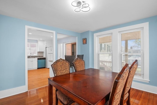 dining area featuring baseboards and light wood-style flooring
