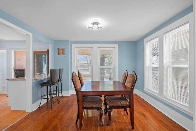 dining area with wood-type flooring and baseboards