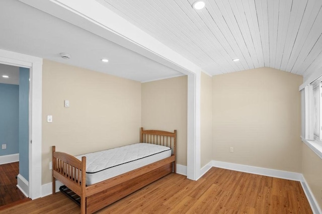 bedroom with baseboards, recessed lighting, light wood-style flooring, and lofted ceiling
