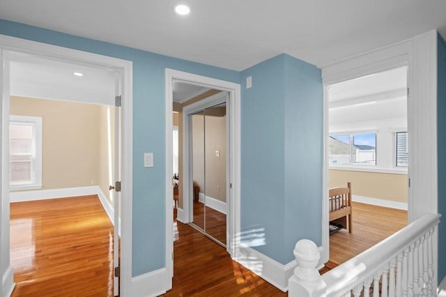 corridor with baseboards, recessed lighting, and wood finished floors