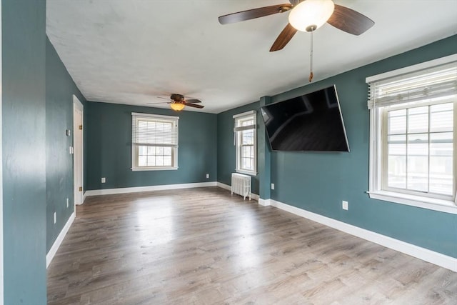 263 Jefferson Ave, Salem, MA 01970 - empty room with radiator, ceiling fan, and wood finished floors
