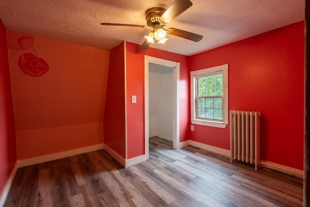 263 Jefferson Ave, Salem, MA 01970 - unfurnished bedroom with radiator, wood finished floors, a textured ceiling, and ceiling fan