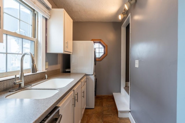 263 Jefferson Ave, Salem, MA 01970 - kitchen featuring stacked washer and clothes dryer, white cabinets, a textured ceiling, and healthy amount of natural light