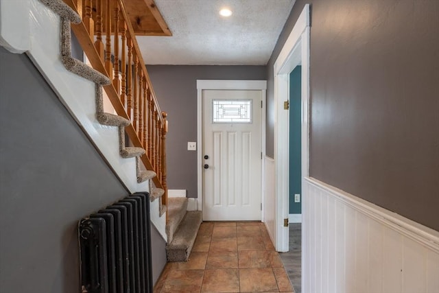 263 Jefferson Ave, Salem, MA 01970 - doorway featuring radiator, wainscoting, stairway, and a textured ceiling