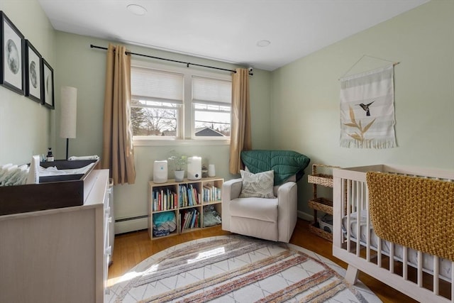living area featuring baseboard heating and wood finished floors