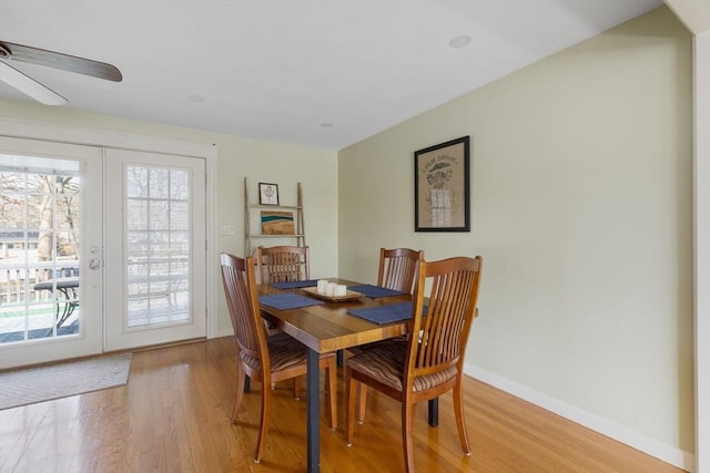 dining area featuring ceiling fan, baseboards, french doors, and light wood finished floors