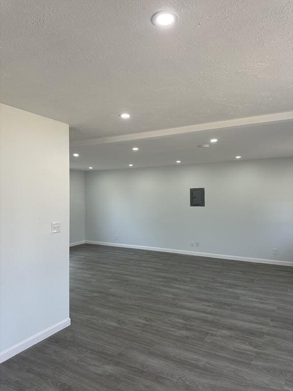 unfurnished room featuring recessed lighting, a textured ceiling, baseboards, and dark wood finished floors