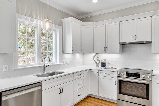 kitchen featuring stainless steel appliances, crown molding, light countertops, under cabinet range hood, and a sink