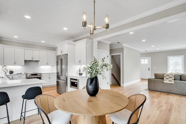 dining room with light wood-style floors, baseboards, ornamental molding, and recessed lighting