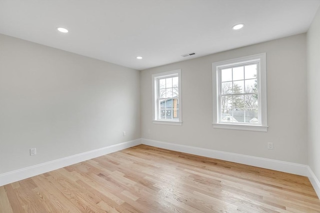 empty room with light wood-style flooring, recessed lighting, visible vents, and baseboards