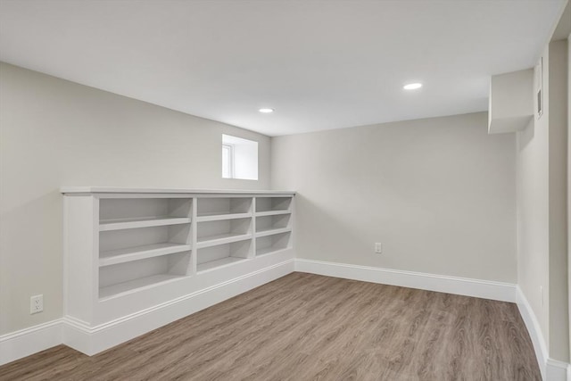 basement with baseboards, wood finished floors, and recessed lighting