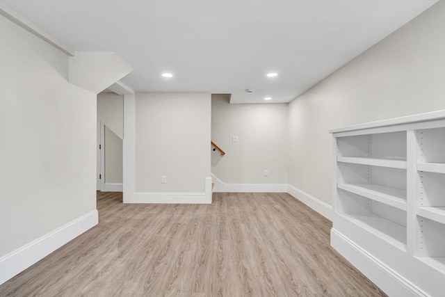 below grade area with stairway, baseboards, and wood finished floors