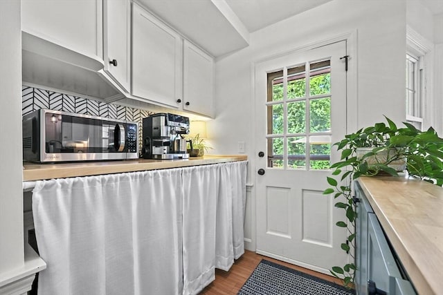 82 Knollwood Dr, Longmeadow, MA 01106 - kitchen featuring stainless steel microwave, light countertops, white cabinets, light wood-type flooring, and backsplash