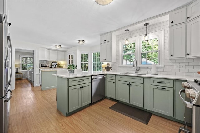 82 Knollwood Dr, Longmeadow, MA 01106 - kitchen featuring green cabinetry, appliances with stainless steel finishes, decorative backsplash, and healthy amount of natural light
