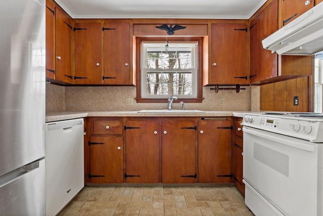 kitchen featuring sink, white appliances, tasteful backsplash, and hanging light fixtures