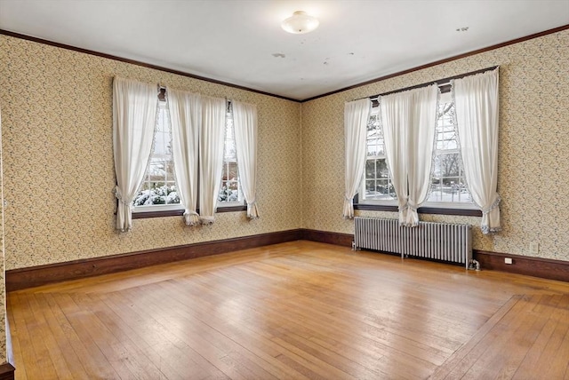 unfurnished room featuring crown molding, wood-type flooring, and radiator