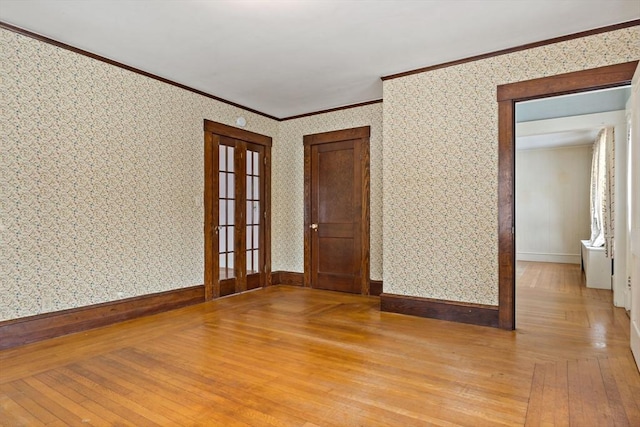 spare room with light hardwood / wood-style floors, ornamental molding, and french doors