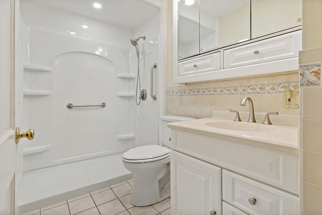 bathroom with toilet, a shower, tile patterned floors, and vanity