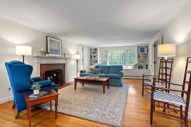 1 Emerson Dr, Acton, MA 01720 - living room with crown molding, built in shelves, wood finished floors, a brick fireplace, and a baseboard heating unit