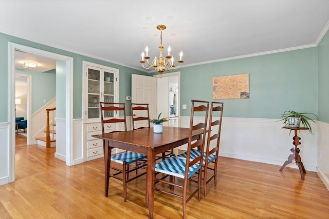 1 Emerson Dr, Acton, MA 01720 - dining area featuring a chandelier, light wood-style floors, stairway, wainscoting, and crown molding