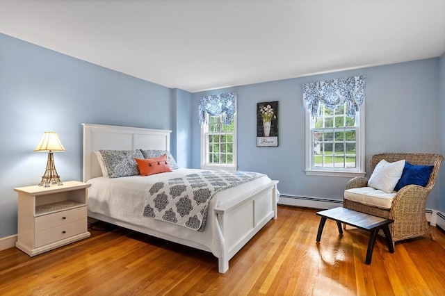 1 Emerson Dr, Acton, MA 01720 - bedroom featuring a baseboard radiator, multiple windows, and light wood finished floors