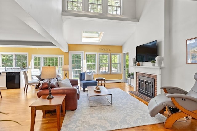 1 Emerson Dr, Acton, MA 01720 - living area with a high ceiling, healthy amount of natural light, a fireplace, light wood-style floors, and a baseboard heating unit