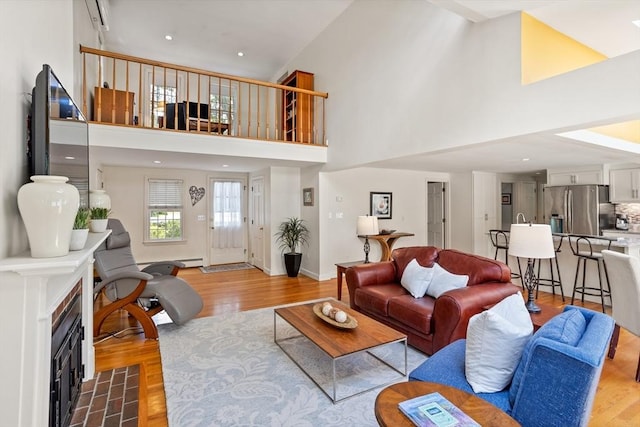 1 Emerson Dr, Acton, MA 01720 - living area featuring a high ceiling, wood finished floors, a baseboard heating unit, baseboards, and a fireplace