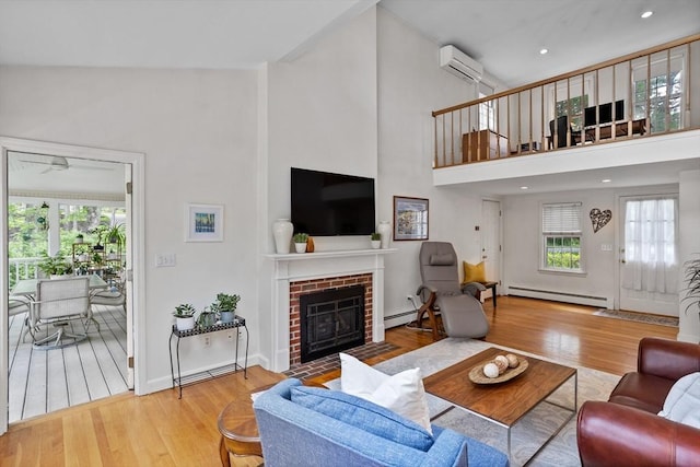 1 Emerson Dr, Acton, MA 01720 - living room with a baseboard heating unit, wood finished floors, a fireplace, a high ceiling, and a wall mounted air conditioner