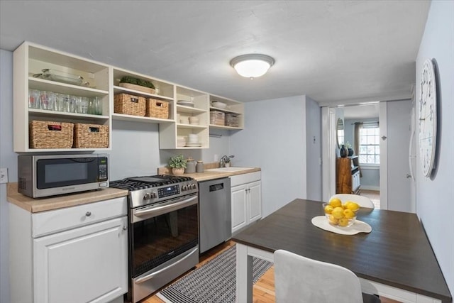 1 Nelson St Unit C, Upton, MA 01568 - kitchen featuring appliances with stainless steel finishes, white cabinetry, open shelves, light countertops, and wood finished floors