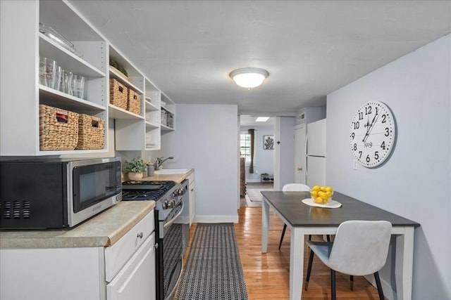 1 Nelson St Unit C, Upton, MA 01568 - kitchen with stainless steel appliances, light wood finished floors, white cabinetry, light countertops, and open shelves