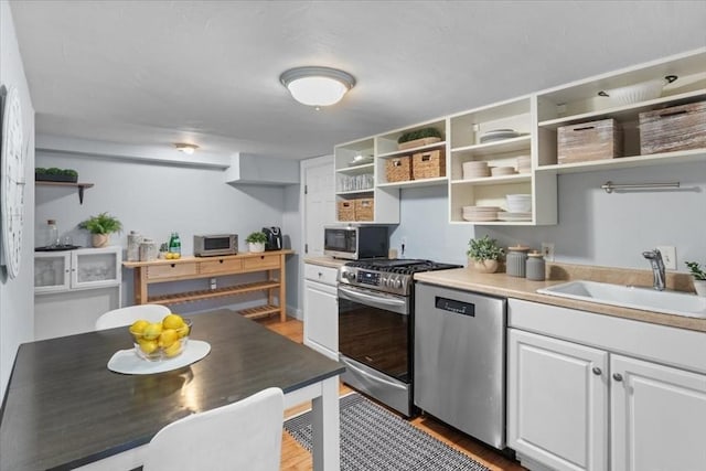 1 Nelson St Unit C, Upton, MA 01568 - kitchen with stainless steel appliances, open shelves, light wood-style flooring, white cabinetry, and light countertops