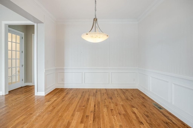 12 Skipping Stone, Plymouth, MA 02360 - unfurnished dining area with light wood-type flooring, a decorative wall, a wainscoted wall, and crown molding