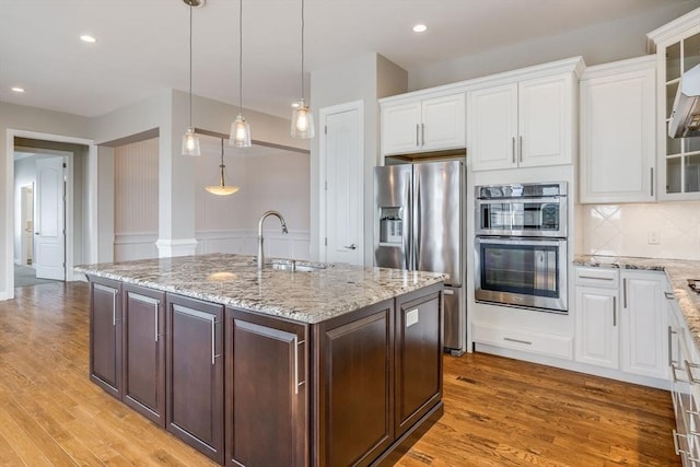 12 Skipping Stone, Plymouth, MA 02360 - kitchen featuring stainless steel appliances, a sink, white cabinetry, glass insert cabinets, and a kitchen island with sink