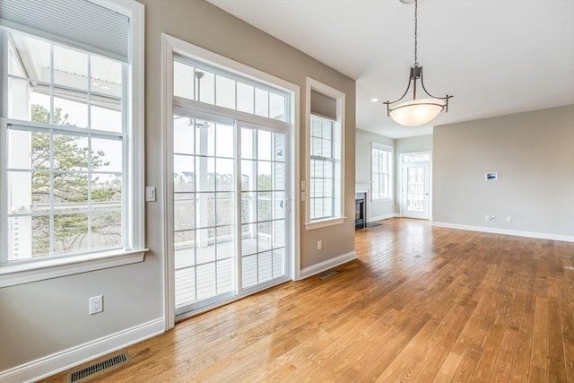 12 Skipping Stone, Plymouth, MA 02360 - unfurnished dining area featuring baseboards, light wood-type flooring, and a fireplace