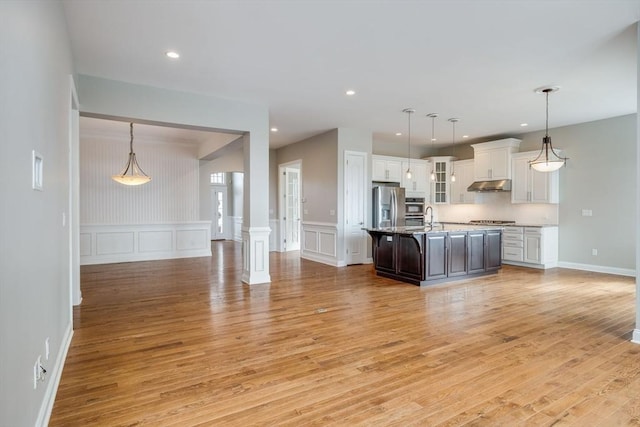 12 Skipping Stone, Plymouth, MA 02360 - kitchen featuring stainless steel appliances, light wood finished floors, white cabinetry, a decorative wall, and under cabinet range hood