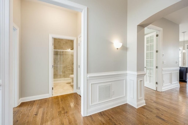 12 Skipping Stone, Plymouth, MA 02360 - corridor featuring wood finished floors, a wainscoted wall, and a decorative wall