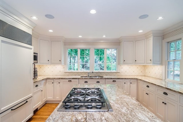 617 S St, Needham, MA 02492 - kitchen featuring appliances with stainless steel finishes, a sink, light wood-type flooring, white cabinetry, and crown molding