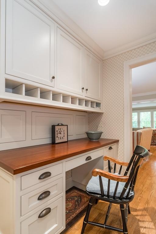 617 S St, Needham, MA 02492 - home office with crown molding, built in study area, light wood finished floors, and wallpapered walls