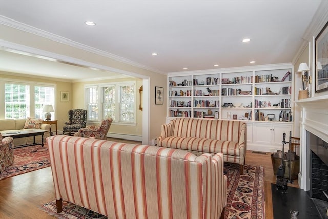 617 S St, Needham, MA 02492 - living room featuring a baseboard heating unit, wood finished floors, a fireplace with flush hearth, recessed lighting, and crown molding