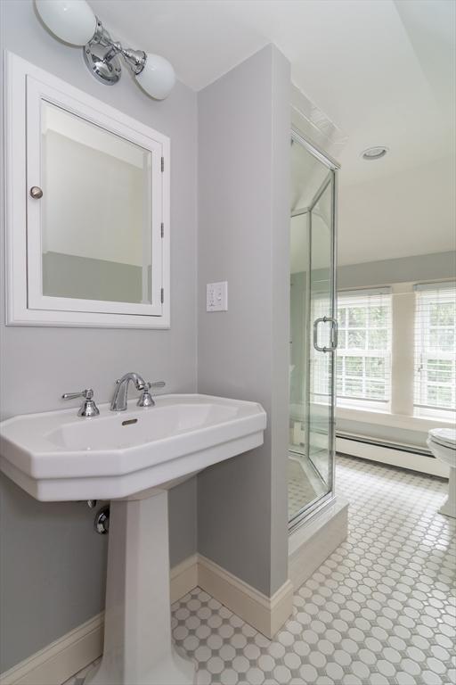 617 S St, Needham, MA 02492 - full bathroom with baseboard heating, a stall shower, baseboards, and a sink