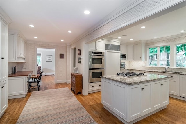 617 S St, Needham, MA 02492 - kitchen with crown molding, stainless steel appliances, a sink, plenty of natural light, and white cabinetry
