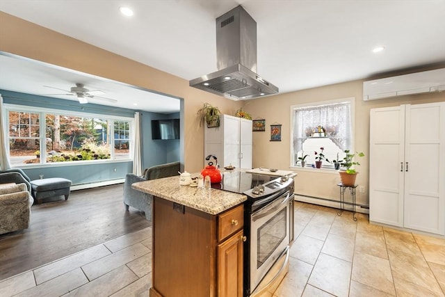 kitchen featuring brown cabinets, island exhaust hood, a baseboard radiator, electric range, and open floor plan