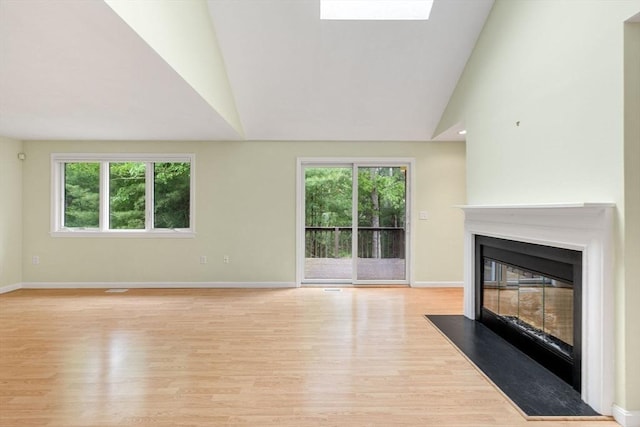 15 Pebble Bch Unit 2005-103, Mashpee, MA 02649 - unfurnished living room featuring light wood finished floors, a fireplace with flush hearth, and vaulted ceiling