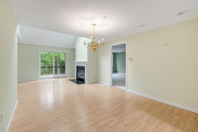 15 Pebble Bch Unit 2005-103, Mashpee, MA 02649 - unfurnished living room featuring light wood-style floors, a chandelier, and a fireplace with flush hearth