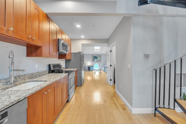 28 Broad St Unit 203, Marlborough, MA 01752 - kitchen featuring stainless steel appliances, light wood-style floors, brown cabinets, and recessed lighting