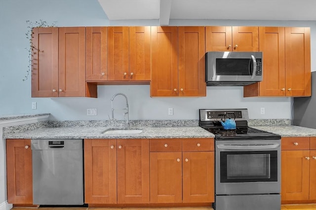 28 Broad St Unit 203, Marlborough, MA 01752 - kitchen with appliances with stainless steel finishes, light stone countertops, and brown cabinets