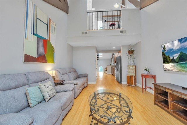 28 Broad St Unit 203, Marlborough, MA 01752 - living area with light wood-type flooring, a high ceiling, and plenty of natural light